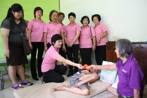 团长郭秋贤分发礼物及红包给爱心之家的一对老夫妇。